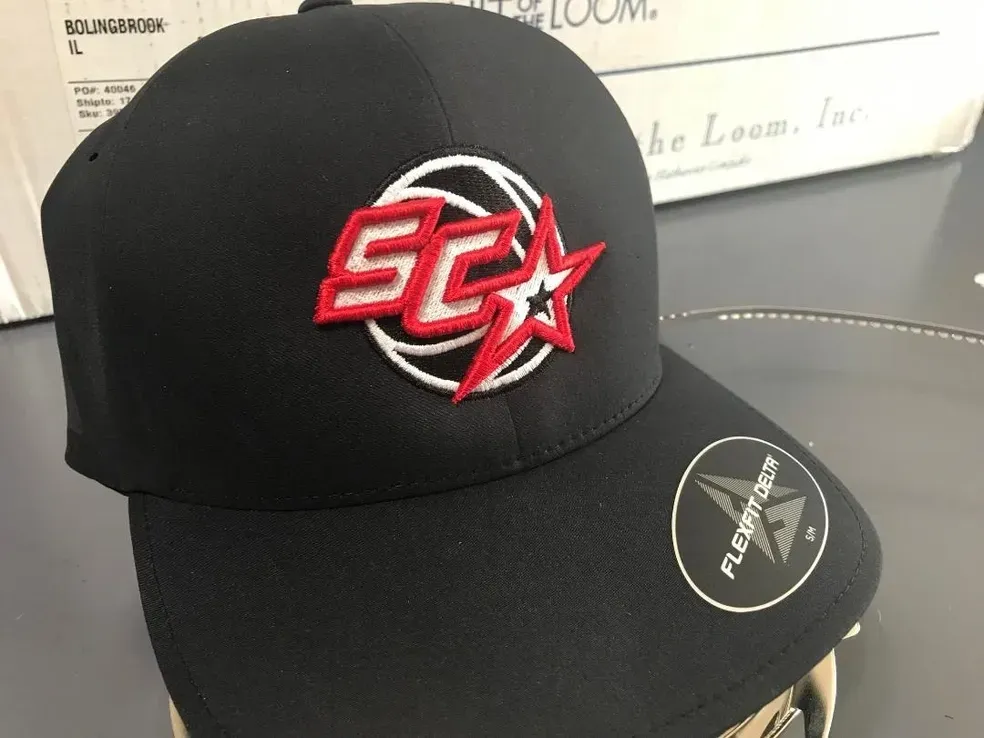 Custom basketball logo with red 3D puff 'SC' and star digitized for a black Flexfit Delta performance cap by Sassy Digitizing.